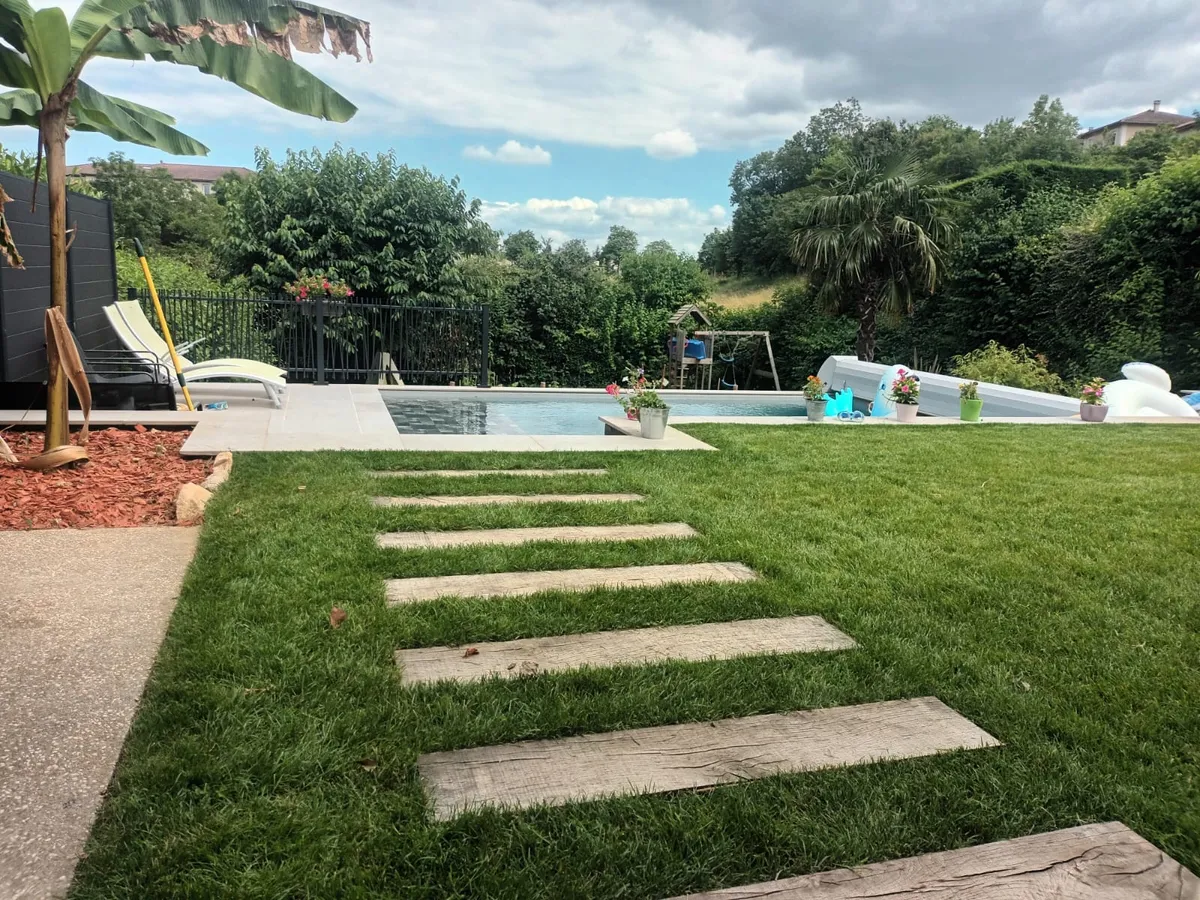 Abords de piscine : plage en bois et gazon